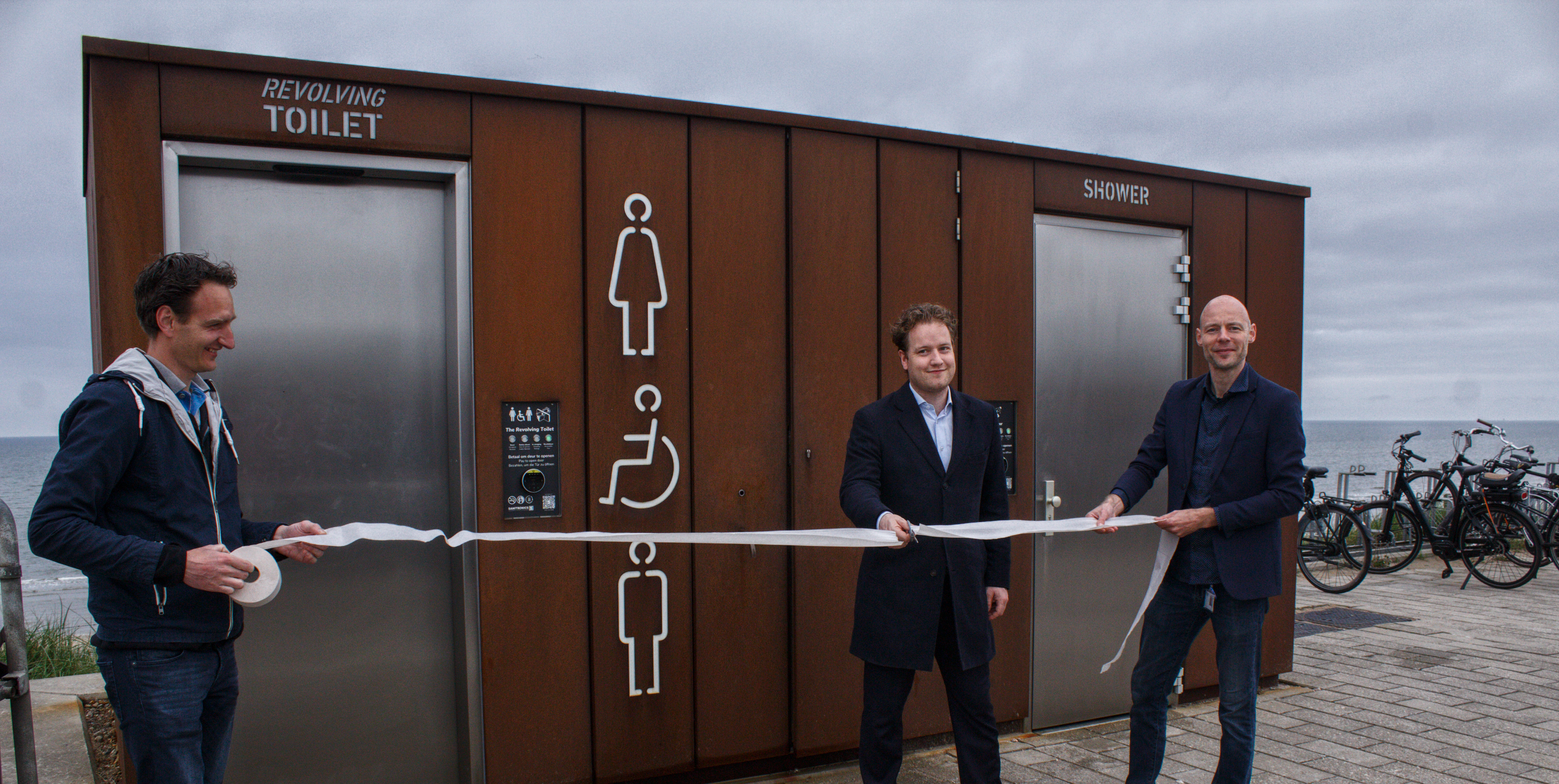 Inauguration officielle des toilettes pivotantes accessibles aux personnes en fauteuil roulant, équipées d'un double urinoir et d'une douche.